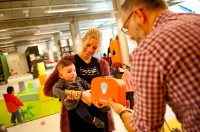 Ouders halen het BoekStart koffertje op in de bibliotheek